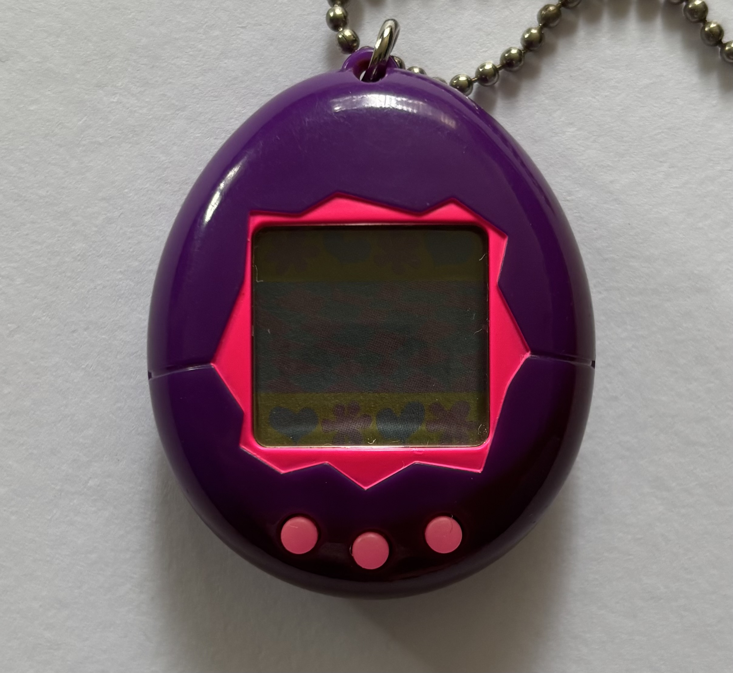 Dark purple shell. Hot pink screen border and buttons.