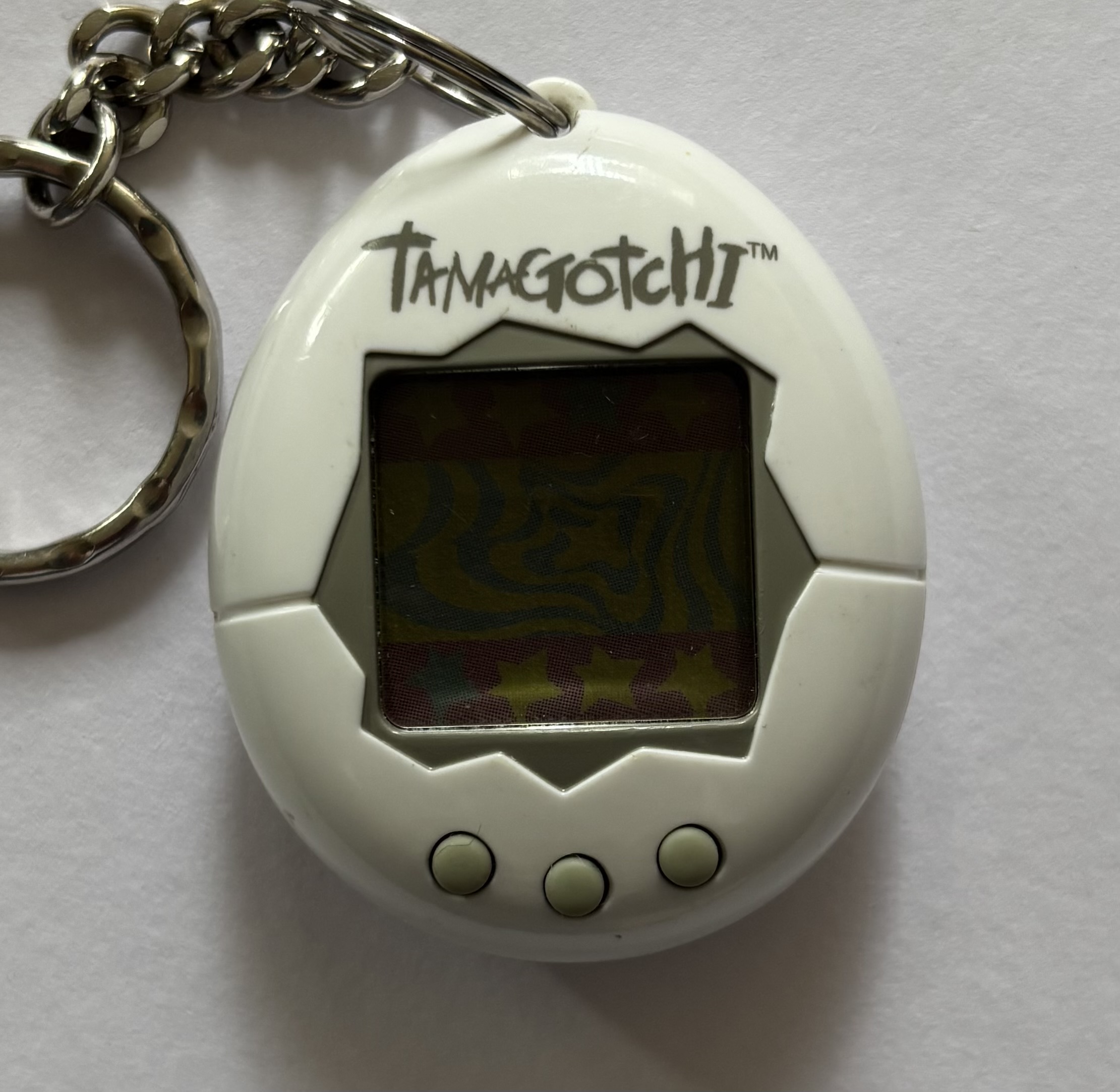 White shell. Gray screen border, buttons, and 'Tamagotchi' label above screen.